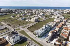 Vista aérea do bairro com empreendimento em destaque, terrenos vizinhos e mar de Ingleses ao fundo — Manhattan Residence em Ingleses, Florianópolis