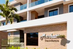 Detalhe da fachada com logotipo Manhattan Residence em relevo sobre parede de tijolo aparente — Manhattan Residence em Ingleses, Florianópolis