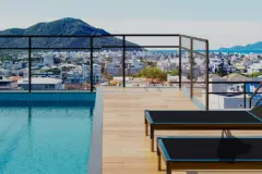 Piscina no rooftop com deck de madeira, espreguiçadeiras e vista para a cidade e o mar — Mar do Norte Studios em Ingleses, Florianópolis