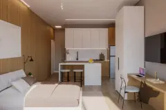 Studio compacto com cama, cozinha americana com bancada e espaço de trabalho com notebook — Mar do Norte Studios em Ingleses, Florianópolis