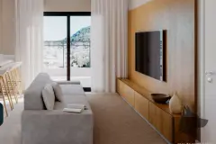 Sala de estar com sofá cinza, painel de TV amadeirado e janela com vista para morros — Mar do Norte Studios em Ingleses, Florianópolis