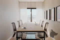 Sala de reuniões com mesa longa, cadeiras e janela com vista para o bairro — Mar do Norte Studios em Ingleses, Florianópolis