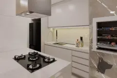 Cozinha com ilha central, cooktop 4 bocas, armários brancos, revestimento de pastilhas bege e adega lateral — Maranello Residence em Balneário, Florianópolis