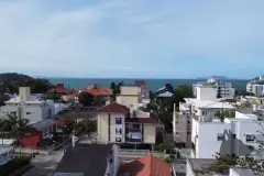 Vista real de Canasvieiras com telhados e mar ao fundo — Marena em Canasvieiras, Florianópolis