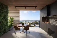 Varanda gourmet com mesa preta, cadeiras de madeira, churrasqueira e jardim vertical, vista para o mar — Marena em Canasvieiras, Florianópolis