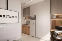 Studio visto do corredor com cama, cozinha compacta e home office, logotipo MaxStudios ao fundo — Max Studios 45 em João Paulo, Florianópolis