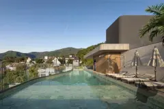 Piscina linear do rooftop com espreguiçadeiras e guarda-sóis, vista para morros, ângulo alternativo — Max Studios 177 em Pantanal, Florianópolis