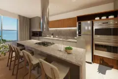 Cozinha com bancada de mármore, cooktop, coifa inox, armários de madeira e janela com vista para o mar — Maxxi View em Jurerê, Florianópolis