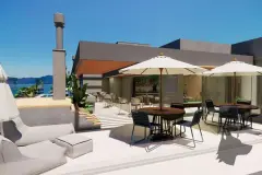 Terraço coberto com espaço gourmet, mesas, guarda-sóis, lareira e piscina ao fundo — Maxxi View em Jurerê, Florianópolis