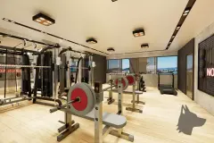 Academia com aparelhos de musculação, halteres, esteiras e vista para o mar — Maxxi View em Jurerê, Florianópolis