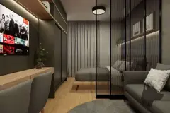 Studio tipo loft com bancada de trabalho, TV, sofá cinza e quarto separado por divisória de vidro — Maxxi View em Jurerê, Florianópolis