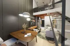 Sala duplex com mesa de jantar, cadeiras, sofá cinza, TV e escada para segundo andar — Maxxi View em Jurerê, Florianópolis