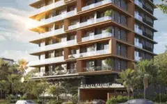Fachada frontal do edifício Meraki Allure com 10 andares em corten marrom e entrada iluminada com letreiro — Meraki Allure em Jurerê, Florianópolis