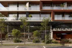 Fachada frontal diurna completa com 10 andares em corten, varandas e terraço com plantas — Meraki Allure em Jurerê, Florianópolis