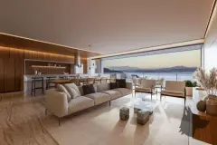 Sala de estar ampla com sofá bege longo, bancada em madeira escura, cozinha integrada e vista panorâmica para o pôr do sol sobre o mar — Meraki Sunset em João Paulo, Florianópolis