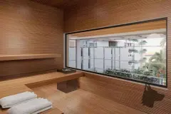 Sauna seca com paredes e banco em cedro ripado, pedra aquecedora e janela com vista para o jardim — Meraki Sunset em João Paulo, Florianópolis