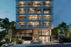 Fachada frontal do edifício Mira Apartments à noite com 6 andares, varandas em ripas de madeira e entrada iluminada — Mirá Apartments em Centro, Florianópolis
