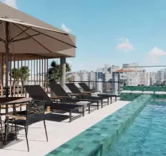 Piscina rooftop com espreguiçadeiras pretas, guarda-sol e vista para o centro de Florianópolis — Mirá Apartments em Centro, Florianópolis