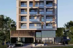 Fachada frontal diurna do edifício Mira Apartments com ripas de madeira no térreo, entrada com letreiro e carros na rua — Mirá Apartments em Centro, Florianópolis
