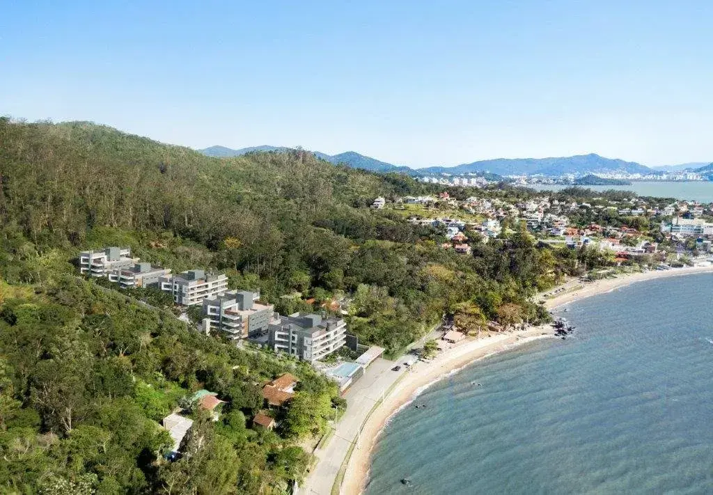 Vista aérea do empreendimento Miragio Cacupé com praia, mata e mar ao fundo em Florianópolis — Miragio en Cacupé, Florianópolis