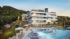 Piscina com espreguiçadeiras, guarda-sóis, jardim florido e fachada do edifício ao entardecer — Miragio en Cacupé, Florianópolis