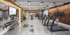 Academia ampla com halteres, esteiras, aparelhos de musculação e parede de tijolos com letreiro Fitness — Miragio en Cacupé, Florianópolis