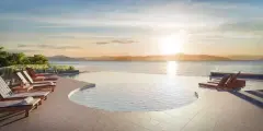 Piscina em curva com espreguiçadeiras e vista panorâmica para o mar e montanhas ao pôr do sol — Miragio en Cacupé, Florianópolis