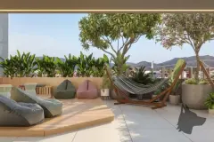 Área de descanso no rooftop com pufes coloridos, rede e plantas tropicais — Mobby Campeche en Campeche, Florianópolis