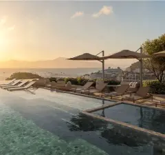 rooftop piscina espreguiçadeiras guarda-sóis vista cidade mar entardecer ângulo frontal — Natus em Ponta das Canas, Florianópolis