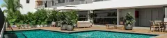piscina deck amplo sofá vasos plantas guarda-sol cadeiras fachada — Neo Continente em Estreito, Florianópolis