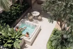spa hidromassagem vista aérea casal banheira externa mesa redonda cadeiras rattan deck pedra creme árvore plantas tropicais — Next Trindade em Trindade, Florianópolis
