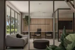coworking sala escritório sofá cinza escrivaninha laptop cadeiras plantas parede madeira divisória vidro — Next Trindade em Trindade, Florianópolis