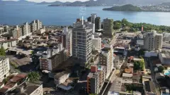 vista aérea drone fachada real edifício Opus Agronômica bairro contexto urbano lagoa mar ilhas logo Opus — Opus em Agronômica, Florianópolis
