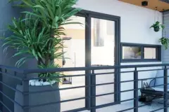 varanda sacada render grades metálicas horizontais cinza planta yuca vasos suspensos cadeiras jardim vista interior — Park View Residence em Coqueiros, Florianópolis