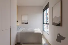 dormitório real cama solteiro armários brancos quadros arte janela vista edifícios piso madeira dia — Parkside Itacorubi em Itacorubi, Florianópolis