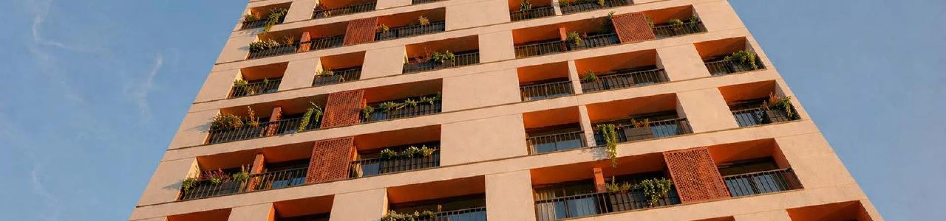 Fachada do Parkside Rio Branco vista de baixo para cima, torre residencial alta com varandas e vegetação nos balcões — Parkside Rio Branco em Centro, Florianópolis