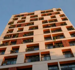 Fachada do Parkside Rio Branco vista de baixo em ângulo alternativo, destacando balcões com vegetação e painéis de madeira — Parkside Rio Branco em Centro, Florianópolis