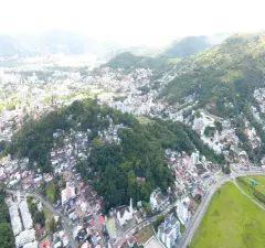 Vista aérea do morro da Cruz e entorno da Carvoeira em Florianópolis, com morros verdes e centro ao fundo — Portal da Carvoeira em Carvoeira, Florianópolis