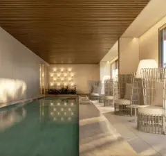 Perspectiva da piscina coberta com cadeiras em rattan e teto ripado, vista lateral aproximada — Puerto Madero em Jurerê, Florianópolis