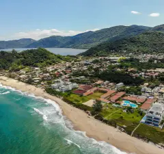 Vista aérea ampla do Morro das Pedras com praia, mar, montanhas verdes e lagoa da Conceição ao fundo — Ravena em Morro das Pedras, Florianópolis