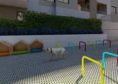 Pet place com casinhas de madeira e obstáculos coloridos para cães, vista do edifício ao fundo — Recanto dos Corais em Abraão, Florianópolis