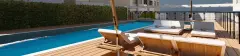Área da piscina com deck de madeira e espreguiçadeiras com guarda-sol — Recanto dos Corais em Abraão, Florianópolis