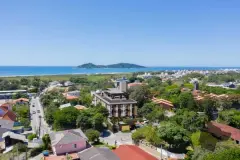 foto aérea drone edifício Residencial Málaga bairro Campeche árvores casas praia ilhote ao fundo dia — Residencial Málaga em Campeche, Florianópolis