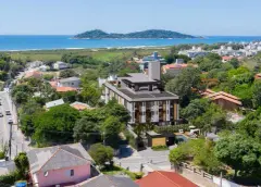 foto aérea drone edifício Residencial Málaga bairro Campeche formato retrato praia ilhote ao fundo dia — Residencial Málaga em Campeche, Florianópolis