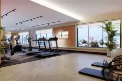 Academia equipada com esteiras, elípticos e TV, janelas com vista panorâmica da cidade — Rosa Branca em Canto, Florianópolis