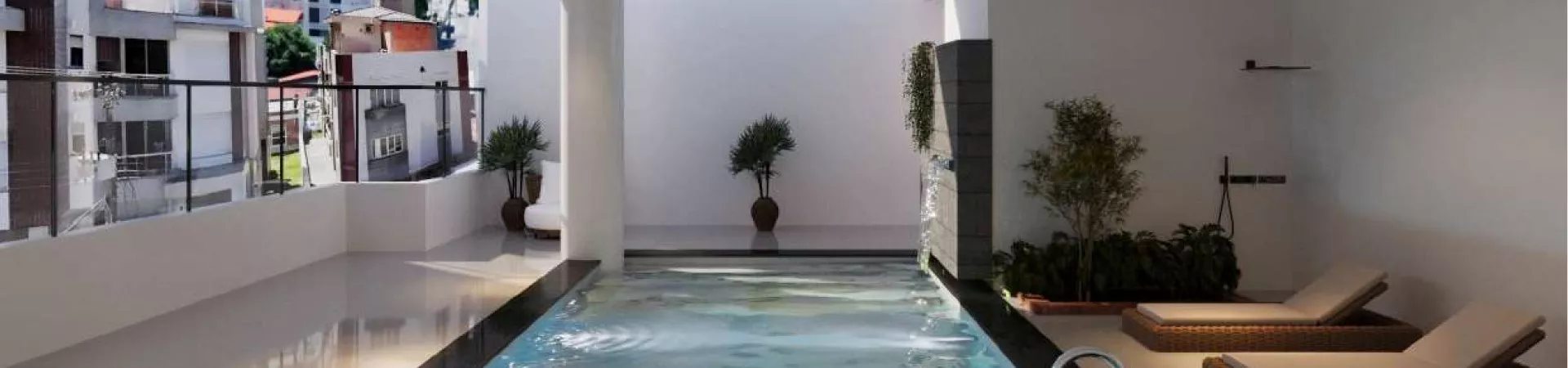 Área da piscina coberta com espreguiçadeiras de vime, cascata de pedra e plantas, vista para o bairro ao fundo — Saint Humbert II em Ingleses, Florianópolis