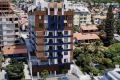 Vista aérea do edifício com revestimento ripado marrom e painéis azuis integrado ao bairro residencial — Saint Humbert II em Ingleses, Florianópolis