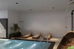Área da piscina coberta com parede de pedra e jardim vertical, cascata e espreguiçadeiras — Saint Humbert II em Ingleses, Florianópolis