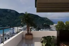 Varanda com vista panorâmica para o mar azul e morro verde, palmeira em vaso e toldo recolhido — Saint Humbert II em Ingleses, Florianópolis