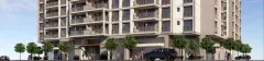 Fachada frontal do edifício com acabamento bege, varandas com guarda-corpo e calçada arborizada — Saint Tropez Residence em Ingleses, Florianópolis